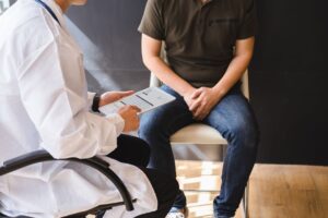 man sitting with hands in lap while talking to doctor